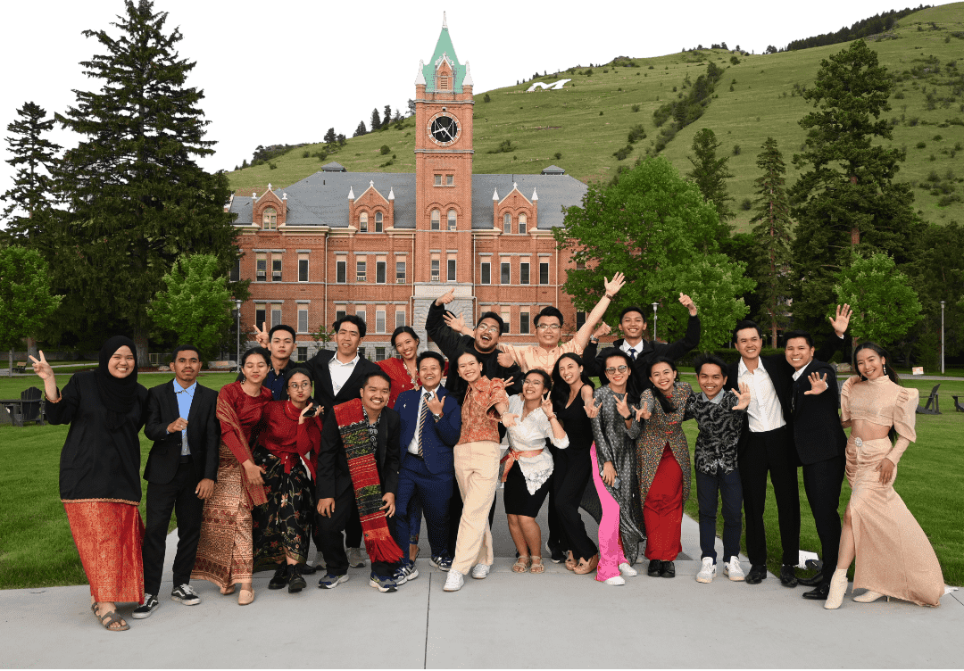 A group of fellows posing in front of Main Hall at the University of Montana